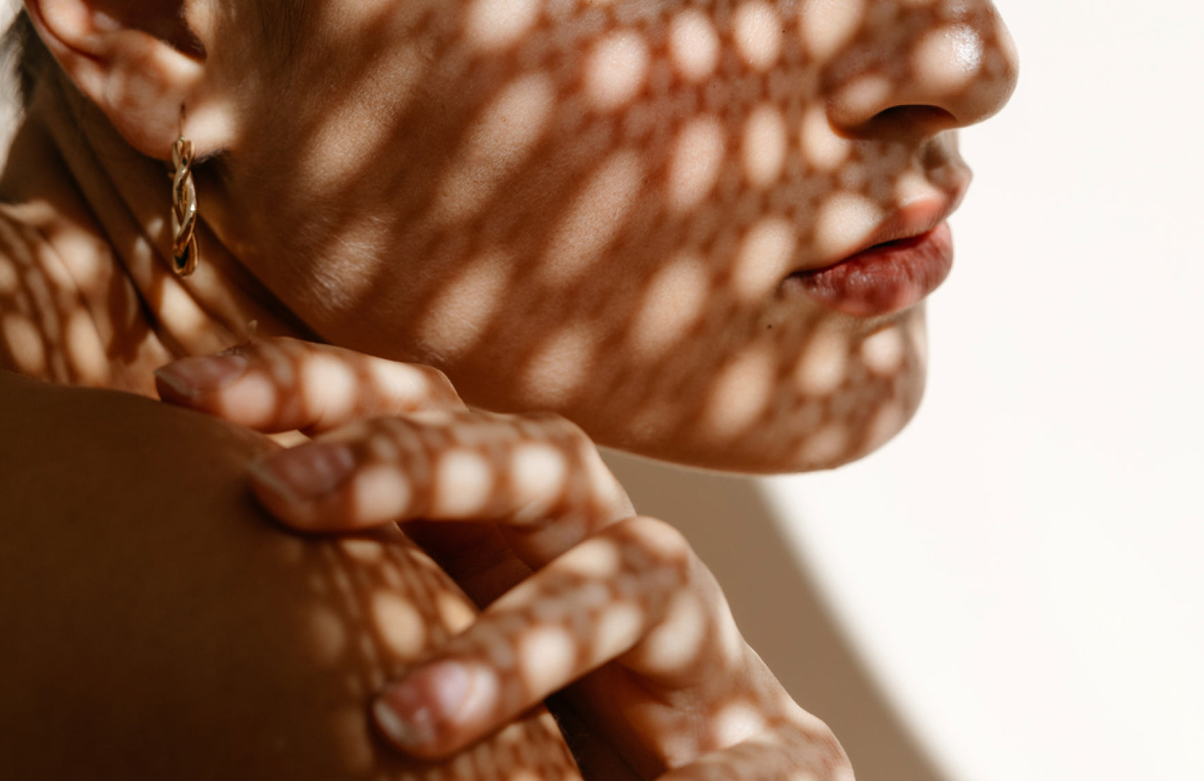 Woman with a pattern reflecting on her face to represent dark spots