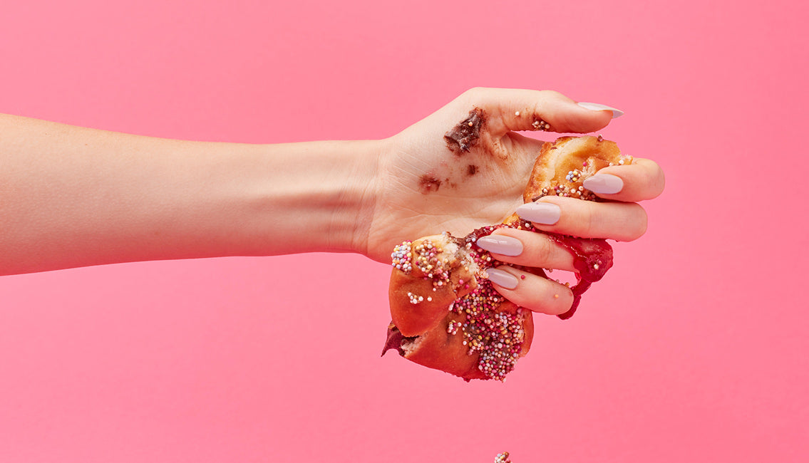 Woman's hand crushing a donut