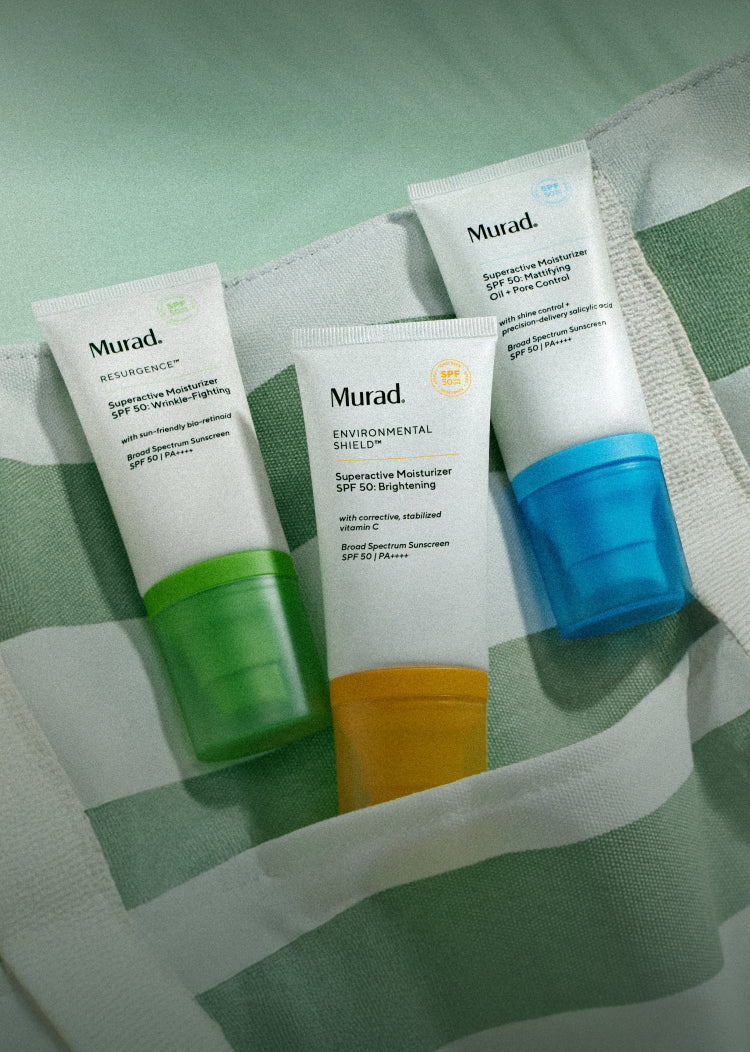 Three Murad skincare products on a textured green surface